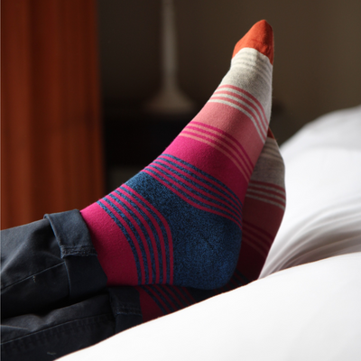 Colorful striped sock on a person's foot with a blurred background