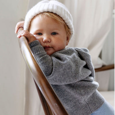 A sumptuous, grey button-down hooded cardigan for baby available in both wool and cashmere is a special treat that every new parent and baby will love, by Corgi Socks.