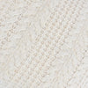 Close-up of a textured white fabric with a cable knit pattern