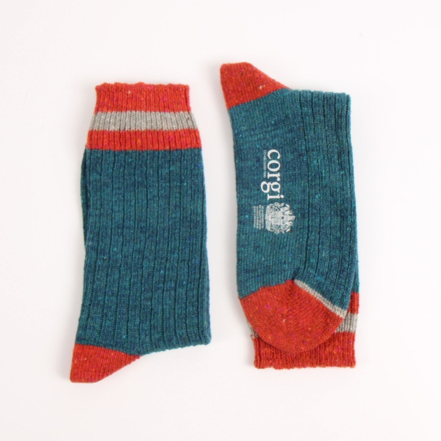 A pair of ribbed knit crew socks in teal blue, with red toes and heels, a red and gray striped cuff, and white 'corgi' branding printed on one sock, displayed on a clean white background.