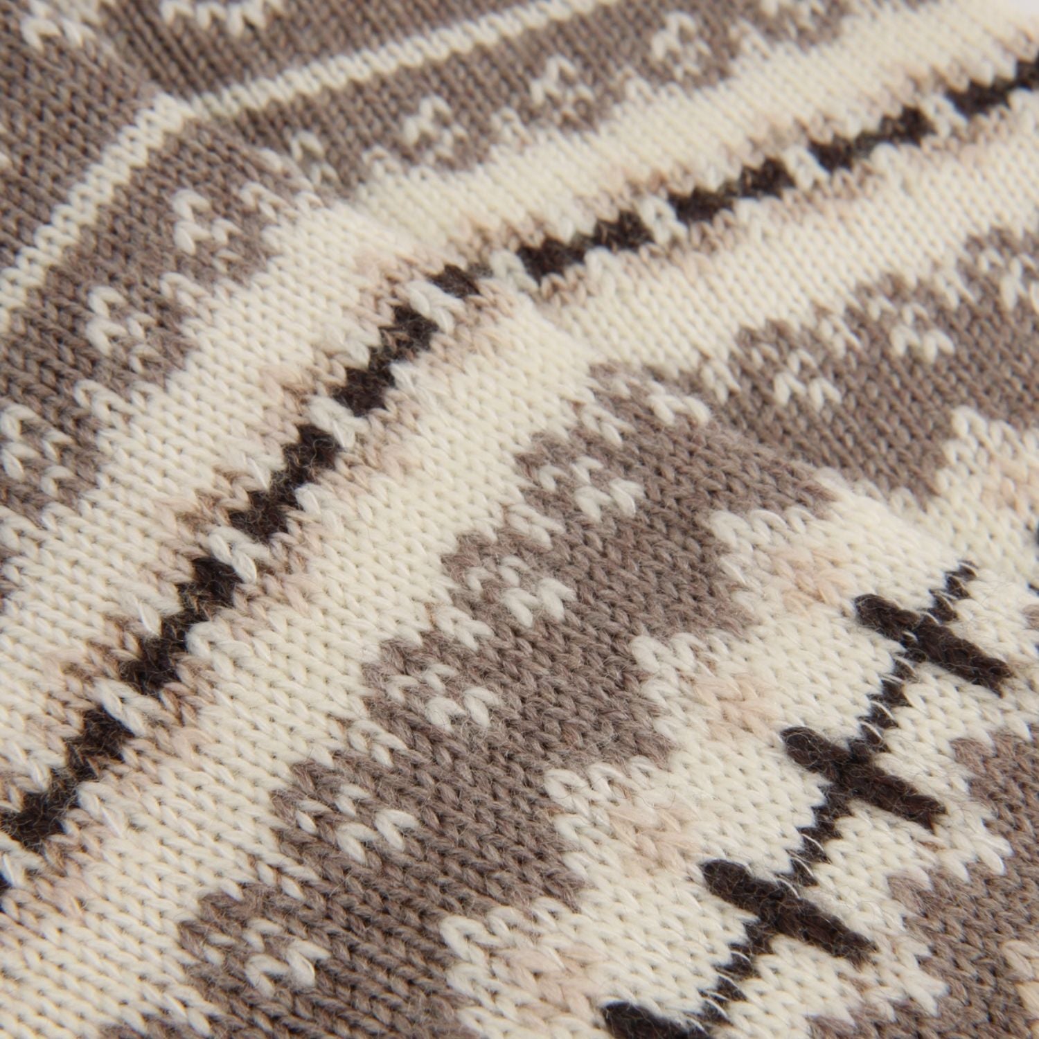 Close-up of a knit fabric with a geometric pattern in cream, taupe, and dark brown.