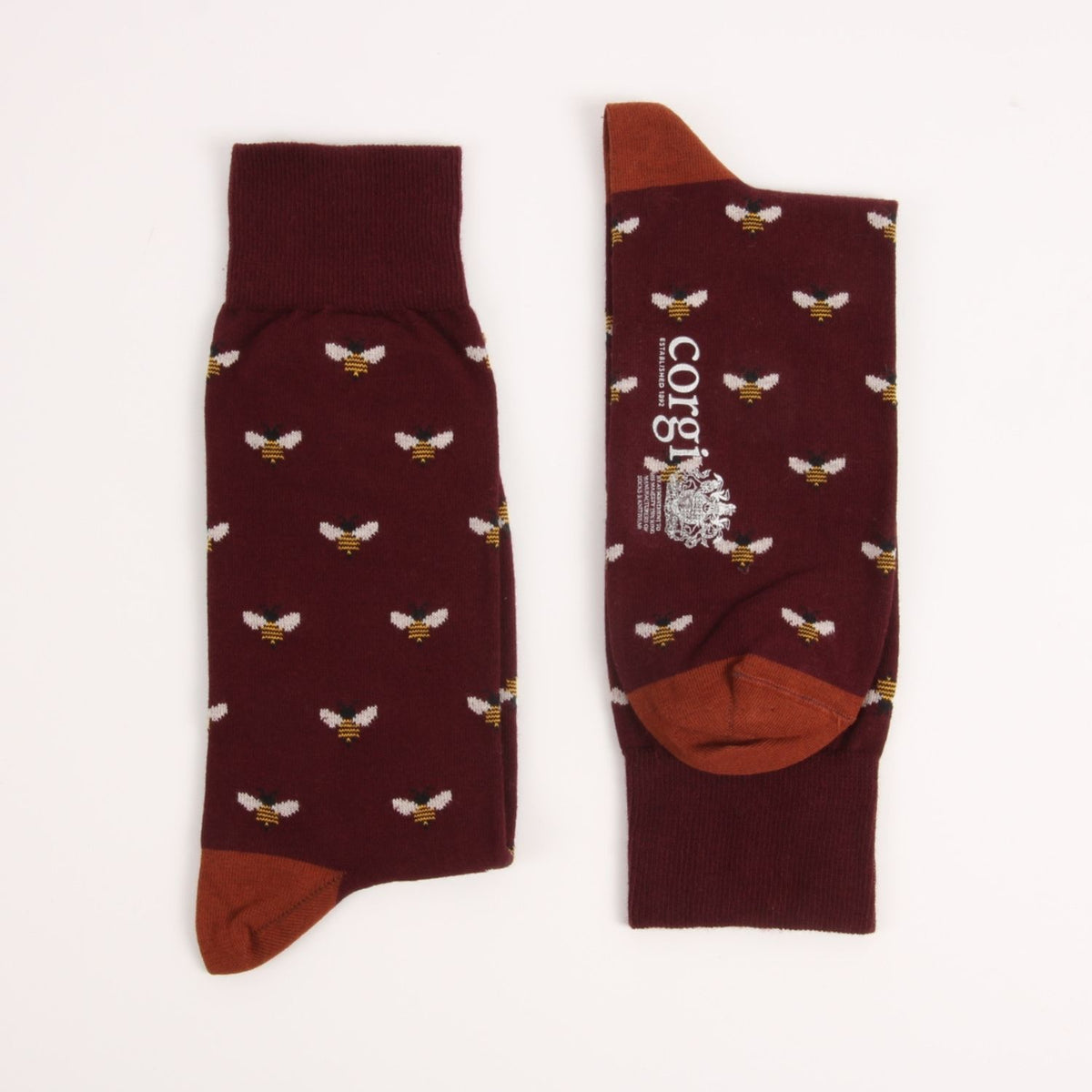 A pair of dark maroon crew socks with a repeating pattern of small white and yellow bees, featuring solid maroon heels, toes, and cuffs, and a white printed brand logo on one sock.