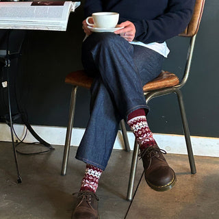 girl wearing red fair isle socks with a coffee and a book 