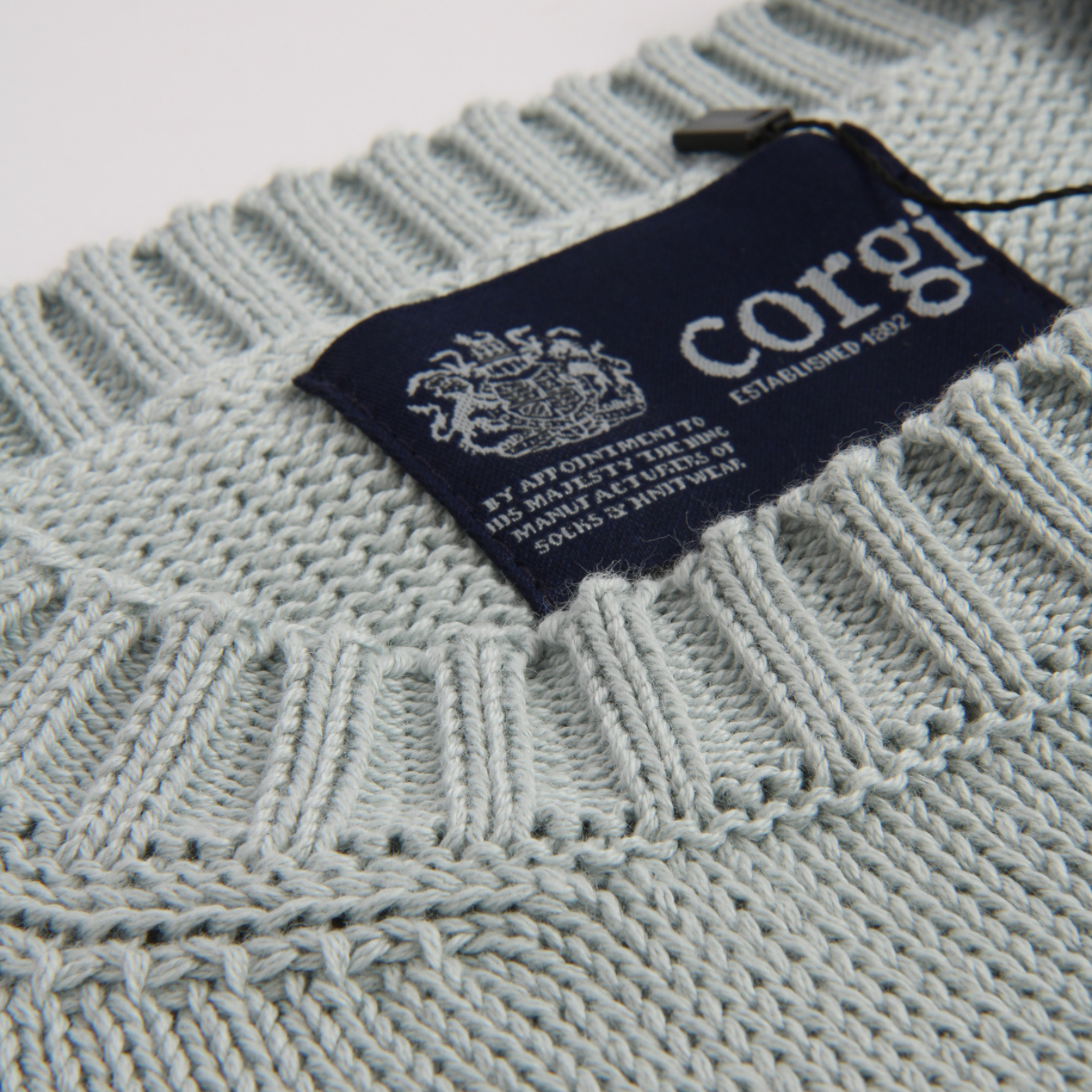 Close-up of a knitted garment with a 'corgi' brand label.