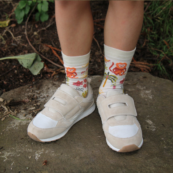 Beige sneakers with floral-patterned socks on a natural background