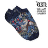 A pair of blue trainer socks with a floral pattern, featuring the 'Strawberry Thief' design by William Morris, worn on someone's feet.