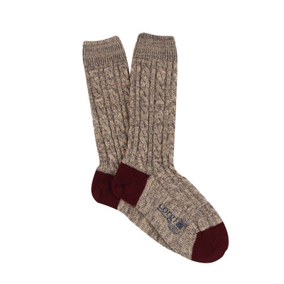 A pair of hand-knitted brown cable cashmere and cotton socks with the brand 'Corgi' visible.